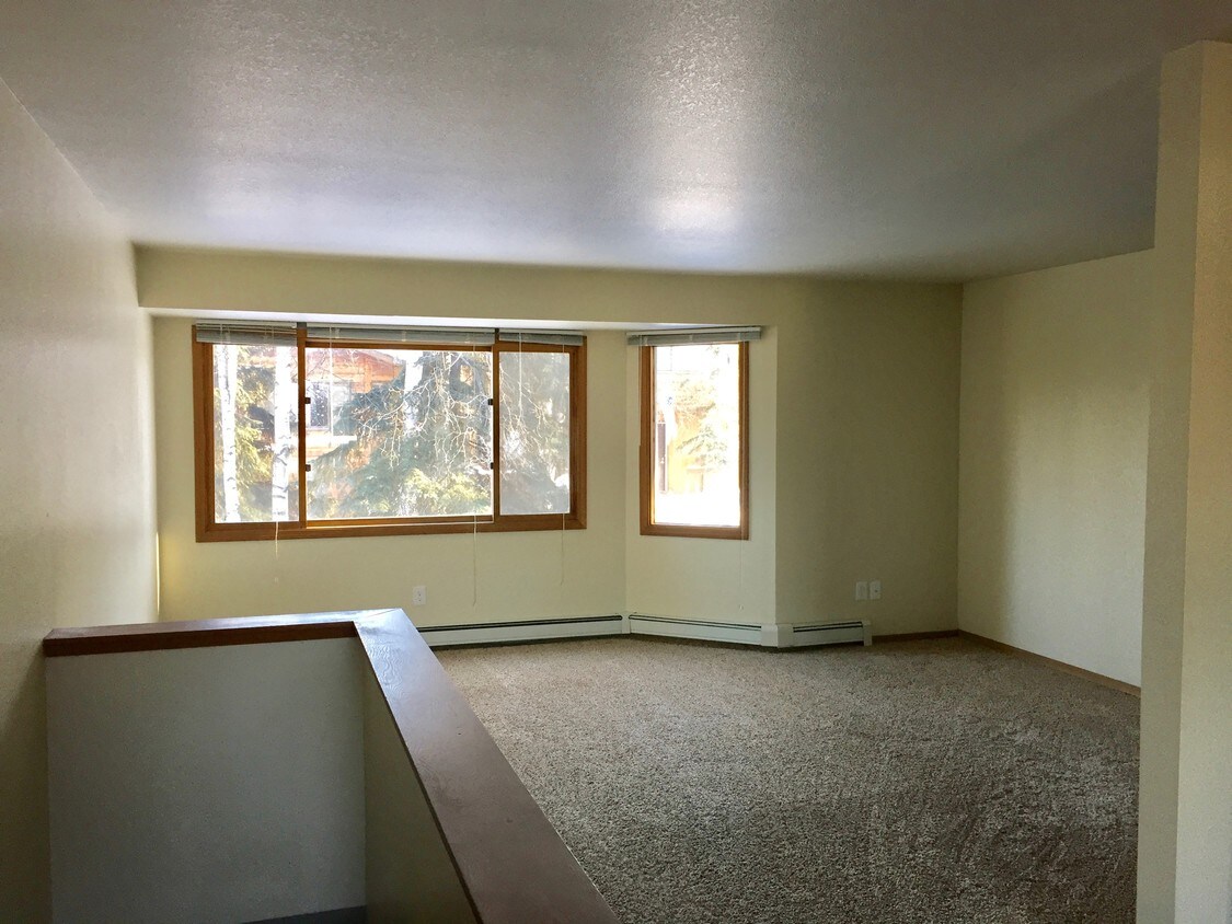 Living room overlooks wooded courtyard - 724 E 76th Ave