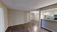 Located at 2250 Little Valley Rd in Hoover, Alabama, this 2-bedroom, 3-bathroom residence offers a practical and comfortable single-floor layout. The open living room features rich wood-look laminate flooring, neutral-toned walls, and a textured ceiling, creating a bright and welcoming atmosphere. A sliding glass door fills the space with natural light. The adjacent kitchen is efficiently designed in a galley style, featuring white cabinetry with modern hardware, granite-style countertops, a double stainless steel sink, and black appliances including a range, microwave, and dishwasher. The combination kitchen and living area flows seamlessly, making it ideal for everyday living. Both bedrooms are carpeted and finished with soft neutral tones, with the spacious primary bedroom offering a window with views of the surrounding greenery. The bathrooms are well-appointed, with one featuring a soaking tub and shower combo with wood-look flooring, and another showcasing a wide vanity with granite-style countertops, white cabinetry, and a well-lit mirror. Two closets provide ample storage throughout the home. The unit is accessed via a covered exterior corridor.
