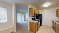 Located at 3070 Mill Pound Drive in Bellbrook, Ohio, this single-floor residence offers a practical and comfortable layout throughout. The galley-style kitchen is well-appointed with warm oak cabinetry lining both walls, light countertops, and a full suite of black appliances including a range, over-the-range microwave, refrigerator, and dishwasher. Tile flooring runs through the kitchen, transitioning to plush neutral carpet in the living areas. The spacious living room is a standout, featuring a tile-surround fireplace and a large sliding glass door fitted with vertical blinds that invites natural light and provides outdoor access. The bedrooms are generously sized with soft carpeting, ample natural light from windows with blinds, and closet storage. Two full bathrooms serve the home, each finished with warm tile flooring, oak vanity cabinetry, light countertops, a tub-shower combination, and a large mirror. The overall palette of neutral tones and consistent finishes creates a clean, cohesive ambiance throughout the home, making it a functional and welcoming space in the Bellbrook community.