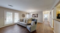 Located at 910 Saint Andrews Drive in Murfreesboro, TN, this single-story, 2-bedroom, 2-bathroom home offers a thoughtfully designed layout that balances comfort and functionality. The open-concept living and dining area is a standout feature, showcasing rich dark hardwood-style flooring, neutral gray walls, and a textured ceiling. Large windows with plantation-style blinds and sliding glass doors fill the space with natural light, while a pendant light above the dining area adds a refined touch.

The kitchen is equipped with warm oak cabinetry, dark granite-style countertops, and black appliances, including a range, microwave, and dishwasher, all set over durable hardwood-style flooring. Both bedrooms feature plush carpeting, ceiling fans, and ample natural light, offering a cozy retreat. The primary bedroom is generously sized, while the second bedroom comfortably accommodates a bed and workspace.

The two bathrooms include wood-toned vanities with dark countertops. A dedicated laundry room with full-size washer and dryer hookups and built-in shelving adds everyday convenience. A separate closet provides additional storage. The home's cohesive, neutral palette and practical layout make it an inviting and efficient living space.