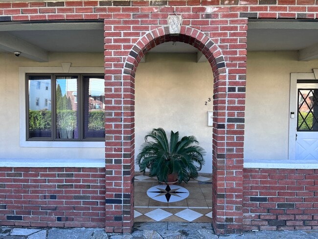 brick arch entry to home with covered porch - 239 Kingston Ave