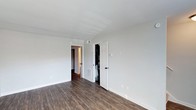 Located at 200 Seven Oaks Rd in Durham, North Carolina, this two-story home offers a well-maintained interior designed for comfortable everyday living. The space features dark hardwood-style flooring that runs throughout, providing a warm contrast against the bright white walls and white trim. Ceilings are clean and smooth, contributing to a fresh, open feel throughout the rooms. The interior layout is thoughtfully organized across two floors, allowing for clear separation between living and private spaces. A standout detail visible throughout is the inclusion of built-in closet storage, with double-door closets offering generous organizational capacity. Doorways are framed cleanly with white molding, and floor vents are strategically placed for consistent climate control. The neutral color palette creates a versatile backdrop well-suited to a variety of interior styles and furnishings. Natural light filters into the rooms, further enhancing the airy, open atmosphere of the home. The overall condition of the space reflects a clean and move-in-ready environment, making it an appealing option for those seeking a straightforward, functional residence in the Durham area.