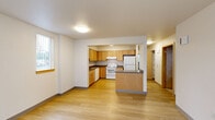 Located at 1605 SE Maple St in Hillsboro, Oregon, this single-story home offers four bedrooms and two bathrooms within a practical and well-organized floor plan. The living room is bright and open, featuring light wood-look flooring and multiple windows with vertical blinds that allow natural light to fill the space. It flows seamlessly into the kitchen, which is equipped with warm wood cabinetry, dark countertops, a peninsula for additional workspace, and white appliances including a range, dishwasher, and refrigerator. The kitchen's light hardwood flooring and ample cabinet storage make it both functional and inviting. The four bedrooms offer a comfortable, quiet retreat; the secondary bedrooms feature plush carpeting and windows with views of the surrounding area, while the primary bedroom provides a cozy, well-proportioned space with closet storage including built-in wire shelving. A hallway connects the bedroom wing to the main living areas. The two bathrooms are clean and functional — one features a dual-sink vanity with wood cabinetry and a granite-style countertop, while the other includes a walk-in shower with a built-in niche and grab bar. Throughout the home, neutral tones and consistent finishes create a cohesive and move-in-ready aesthetic.