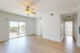 Located in Jacksonville Beach, FL, this well-appointed 2-bedroom, 2-bathroom residence offers a bright and functional single-floor layout. The open-concept living, dining, and kitchen area serves as the heart of the home, featuring light wood-style flooring, a ceiling fan, and a sliding glass door that leads to a private balcony with outdoor views. The kitchen is thoughtfully designed with white shaker cabinetry, quartz countertops, a double stainless steel sink, a blue subway tile backsplash, stainless steel appliances, and pendant lighting. The primary bedroom is generously sized, filled with natural light from multiple windows, and finished with plush carpet and a ceiling fan. The second bedroom is equally comfortable, also carpeted with a window and ceiling fan. A dedicated office space adds flexibility to the layout. The bathrooms are clean and modern, with one featuring a glass-enclosed walk-in shower with large-format neutral tile. Additional conveniences include a laundry area, two closets, and two hallways that connect the spaces efficiently. The overall ambiance is light, airy, and move-in ready, with a clean neutral palette throughout.