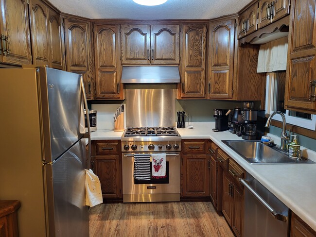 Kitchen with stainless steel high end Thermador gas range and dishwasher! - 8460 Red Oak Dr