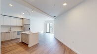 Located at 1991 Main Street in the heart of Sarasota, FL, this modern 1-bedroom, 2-bathroom residence offers a thoughtfully designed open-concept layout with clean lines and contemporary finishes throughout. Light wood-tone flooring flows seamlessly across the living areas, complementing the bright white walls and recessed lighting that create an airy, welcoming ambiance.

The kitchen is a standout feature, showcasing flat-front cabinetry in a warm wood finish paired with crisp white upper cabinets, light quartz countertops, a central island, and stainless steel appliances including a refrigerator, range, microwave, and dishwasher. The open layout transitions effortlessly into the spacious living room, which is bathed in natural light from large floor-to-ceiling sliding glass doors that open to a private balcony with outdoor views.

The generously sized primary bedroom continues the light hardwood flooring and features its own sliding glass door access to the balcony, along with a dedicated closet. The primary bathroom is elegantly appointed with marble-look tile flooring, a wood-vanity, white countertop, and a frameless glass walk-in shower. A second bathroom offers a similarly refined aesthetic. Completing the unit is a dedicated laundry room with full-size Whirlpool washer and dryer.