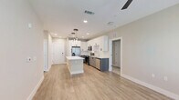 Located in Sanford, FL, this well-appointed 2-bedroom, 3-bathroom residence offers a thoughtfully designed single-floor layout with generous living space. The open-concept kitchen and living area serves as the heart of the home, showcasing a large center island with quartz countertops, crisp white upper cabinetry, contrasting grey lower cabinets, and a full suite of stainless steel appliances. Statement pendant lighting adds a modern touch above the island, while light wood-look flooring extends throughout the main living areas. The bedrooms are carpeted for comfort, each featuring ceiling fans and windows with blinds that invite natural light. The primary bedroom is notably spacious and includes a dedicated walk-in closet with wire shelving systems for ample storage. The bathrooms are finished to a high standard, with one featuring a double-sink vanity with grey cabinetry, a bold-framed mirror, and a glass-enclosed shower adorned with elegant marble-look tile. Two dedicated closets provide additional storage throughout the residence. The overall aesthetic is clean and contemporary, with neutral tones, modern fixtures, and quality finishes creating a bright, cohesive ambiance throughout.