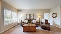 Located at 5399 Waterford Cir in Sheffield, Ohio, this single-floor residence offers a thoughtfully designed layout with a warm, neutral palette throughout. The living room serves as the heart of the home, featuring plush carpeting, recessed lighting, and a vaulted ceiling that enhances the sense of openness. The space flows naturally into a dedicated dining area, carpeted and intimate, ideal for everyday meals or casual entertaining.

The kitchen is well-equipped with rich cherry cabinetry, tile flooring, and a central island topped with granite, providing ample prep and storage space. White appliances complement the warm cabinetry tones, and direct access to the laundry room adds functional convenience. The laundry room itself includes a washer and dryer, a utility sink with cabinetry below, and wire shelving above for additional storage.

The bedrooms are carpeted and quietly positioned, offering a restful retreat. One flexible room features a large window with views of the surrounding greenery, making it suitable as a bedroom or sitting room. The full bathroom includes a wood-toned vanity, tile flooring, and a shower-tub combination. Throughout the home, neutral walls and natural light create a cohesive, welcoming ambiance.