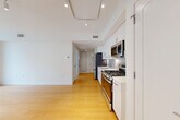 This thoughtfully designed one-bedroom, one-bathroom residence at 605 Concord Ave in Cambridge, MA offers a clean, modern aesthetic throughout its efficiently laid-out single floor. Light-toned hardwood flooring runs continuously through the main living spaces, complementing the bright white walls and creating a cohesive, airy feel.

The open-plan kitchen and living area serves as the heart of the unit. The kitchen is outfitted with stainless steel appliances — including a gas range, built-in microwave, dishwasher, and refrigerator — set against a tasteful tile backsplash. Crisp white cabinetry extending to the ceiling and light quartz countertops complete the polished look. Rail lighting overhead adds both function and style to the combined space.

The living area opens directly to a private outdoor deck through full-height glass French doors, inviting natural light and providing a seamless indoor-outdoor connection with neighborhood views.

The bedroom is a well-proportioned, quiet retreat featuring two sets of double closets and a large window that further enhances the sense of space and light. Three closets total are available throughout the unit.

The bathroom features a floating white vanity with a quartz countertop, undermount sink, and a large mirror. In-unit laundry facilities add everyday convenience, rounding out this well-appointed Cambridge residence.
