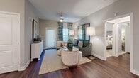 This single-floor residence offers a thoughtfully designed layout with a cohesive aesthetic that blends contemporary finishes with warm, inviting touches. The living area features rich hardwood-style flooring, neutral gray walls, and large windows dressed with botanical-print curtains that fill the space with natural light. A ceiling fan adds a functional accent overhead, while double doors open seamlessly into the bedroom, enhancing the open flow of the floor plan.

The kitchen is outfitted with crisp white shaker cabinetry, dark countertops, a gray subway tile backsplash, and a full suite of stainless steel appliances, including a French door refrigerator, range, and over-the-range microwave. The layout provides ample counter and storage space for everyday use.

Both bedrooms are generously sized and carpeted or finished with hardwood-style flooring. One bedroom features a bold tropical-print aesthetic with direct bathroom access, while the second offers a softer, neutral palette with a ceiling fan and natural light from a large window.

The bathrooms are well-finished, each featuring white vanities with dark countertops, wide mirrors, and soaking tubs surrounded by dark subway tile, creating a clean, modern contrast. The overall ambiance of the residence is polished and cohesive, offering comfort and style throughout every room.