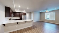 Located at 2740 E Shepherd Ave in Fresno, CA, this well-appointed 2-bedroom, 2-bathroom residence offers a thoughtfully designed single-floor layout. The open-concept living, dining, and kitchen area serves as the heart of the home, featuring light wood-style flooring, recessed lighting, and generous natural light from multiple windows. The kitchen is a standout, outfitted with rich dark-stained cabinetry, white countertops, a breakfast bar with seating, and a full suite of stainless steel appliances including a gas range, microwave, and refrigerator. The spacious primary bedroom includes a ceiling fan, wood-style flooring, and ample closet space. The second bedroom is carpeted and features corner windows that invite natural light and outdoor views, along with its own ceiling fan. Both bathrooms are finished with dark wood vanities, white countertops, and light tile flooring. Storage is plentiful throughout, with four closets including a walk-in closet with built-in shelving and hanging rods. Additional conveniences include an in-unit laundry area, a utility room, and a private balcony. The overall aesthetic is clean and modern, with a neutral color palette that creates a bright, welcoming ambiance throughout.