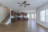 Located at 255 Dublin Way in Dallas, Georgia, this two-story home offers a well-designed layout across two levels with a cohesive, neutral color palette and quality finishes throughout. The open-concept main level features hardwood-style flooring that flows seamlessly through the living and dining areas. The kitchen is a standout, appointed with rich dark wood cabinetry, granite countertops, a subway tile backsplash, stainless steel appliances including a range and built-in microwave, and a central island with pendant lighting. A bright dining nook framed by multiple windows fills the space with natural light. Tray ceilings with crown molding add architectural elegance to one of the main-level rooms. The bedrooms are well-proportioned, with plush carpeting and ample windows offering views of the surrounding greenery. Walk-in closets are fitted with wire shelving systems for organized storage. A dedicated laundry room includes washer and dryer hookups and hardwood-style flooring for easy maintenance. The bathroom features dark wood vanity cabinetry, granite countertops, and a tub-shower combination. Completing the home is a spacious two-car garage with an automatic opener and windowed panels that allow natural light to filter in.