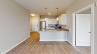 Located at 1906 Research Center Dr in Blacksburg, VA, this single-floor unit offers a clean, modern design with a neutral color palette throughout. The open-concept living area features light hardwood-style flooring, a ceiling fan, and direct access to an outdoor balcony through a glass-panel door, allowing ample natural light to fill the space.

The kitchen is a standout feature, equipped with white shaker-style cabinetry, granite countertops, a peninsula with pendant lighting, a stainless steel refrigerator, range, microwave, and a deep undermount sink — all complementing the light hardwood-style flooring that flows throughout the main living areas.

The bedrooms are carpeted for comfort and include ceiling fans and large windows that bring in generous natural light and outdoor views. One bedroom benefits from a spacious walk-in closet outfitted with multi-tiered wire shelving, providing practical and well-organized storage.

The unit includes multiple full bathrooms, each featuring a tub-shower combination with tiled surrounds, hardwood-style flooring, and granite-topped vanities. The overall design is consistent and well-appointed, emphasizing clean lines, functional layouts, and contemporary finishes throughout every room.