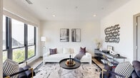 This thoughtfully designed 1-bedroom, 1-bathroom residence offers an efficient and stylish single-floor layout that maximizes every square foot. The open-concept living, dining, and kitchen area forms the heart of the home, anchored by light-toned hardwood flooring that flows seamlessly throughout. The living room features recessed lighting, crisp white walls, and large windows that invite an abundance of natural light, creating a bright and airy atmosphere. Floor-to-ceiling windows at the far end of the space frame sweeping outdoor views and lead to a private balcony, further enhancing the sense of openness.

The kitchen is outfitted with white shaker-style cabinetry, light quartz countertops, a classic tile backsplash, and a full suite of stainless steel appliances. The adjacent dining area is distinguished by striking geometric pendant lighting above a round dining table. The bedroom offers a calm, neutral retreat with plush carpeting, recessed lighting, a ceiling fan, and a sliding barn door. The bathroom features elegant marble-look tile flooring, a tub-shower combination, and a clean, modern finish. A hallway and dedicated closet round out this well-planned residence.