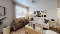 This single-floor residence offers a thoughtfully designed layout that balances modern aesthetics with everyday functionality. The open-concept kitchen serves as a centerpiece, showcasing rich walnut-toned cabinetry, white quartz countertops, a subway tile backsplash, stainless steel appliances, and a large island with bar seating illuminated by pendant lighting. Wood-look flooring flows through the kitchen and living areas, adding warmth and continuity. A sliding glass door in the kitchen provides direct access to the outdoors and brings in additional natural light. The living room is bright and welcoming, featuring large windows with blinds and curtains that frame outdoor views, creating a comfortable space for relaxing or entertaining. Two well-sized bedrooms are carpeted and filled with natural light from large windows. Each room offers ample space for a full bedroom suite. Both bathrooms are finished with wood-tone vanities, white quartz countertops, large mirrors with overhead lighting, wood-look flooring, and a shower-tub combination. The overall design palette is neutral and contemporary, with clean lines and quality finishes carried consistently throughout the space, resulting in a cohesive and inviting home environment.