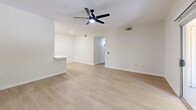 Located at 7401 E Speedway Blvd in Tucson, Arizona, this single-floor, 2-bedroom, 2-bathroom home offers a clean, modern aesthetic throughout. The open-concept living area features light wood-look flooring, crisp white walls, and a ceiling fan, creating a bright and airy atmosphere. A pass-through counter connects the living room to the galley-style kitchen, which is equipped with light maple cabinetry, white quartz countertops, stainless steel appliances including a refrigerator, electric range, over-the-range microwave, and dishwasher, all accented by matte black hardware. Both bedrooms are comfortably sized, with plush wall-to-wall carpeting, ceiling fans, and windows fitted with blinds that frame views of the surrounding greenery. The primary bedroom offers a private, restful retreat. The two bathrooms are identically appointed with light wood vanities, white quartz counters, matte black fixtures, tiled tub-shower combinations, and modern vanity lighting. A dedicated laundry area includes an in-unit washer with overhead shelving for added storage. The hallway connects all rooms efficiently, completing a functional and cohesive single-level layout ideal for comfortable everyday living.
