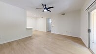 Located at 7401 E Speedway Blvd in Tucson, Arizona, this single-floor, 2-bedroom, 2-bathroom home offers a clean, modern aesthetic throughout. The open-concept living area features light wood-look flooring, crisp white walls, and a ceiling fan, creating a bright and airy atmosphere. A pass-through counter connects the living room to the galley-style kitchen, which is equipped with light maple cabinetry, white quartz countertops, stainless steel appliances including a refrigerator, electric range, over-the-range microwave, and dishwasher, all accented by matte black hardware. Both bedrooms are comfortably sized, with plush wall-to-wall carpeting, ceiling fans, and windows fitted with blinds that frame views of the surrounding greenery. The primary bedroom offers a private, restful retreat. The two bathrooms are identically appointed with light wood vanities, white quartz counters, matte black fixtures, tiled tub-shower combinations, and modern vanity lighting. A dedicated laundry area includes an in-unit washer with overhead shelving for added storage. The hallway connects all rooms efficiently, completing a functional and cohesive single-level layout ideal for comfortable everyday living.