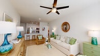Located at 10293 Cassle Rd in Denham Springs, Louisiana, this well-designed single-story home offers a thoughtful layout across two bedrooms, two bathrooms, and two closets. Light wood-style flooring flows consistently throughout, complementing the crisp white walls and recessed lighting that give the space a clean, modern feel.

The open-concept living area is anchored by a ceiling fan and a bank of large windows that flood the room with natural light and offer pleasant outdoor views. The space transitions seamlessly into a dining area and the kitchen, which features white shaker-style cabinetry, granite countertops, a kitchen island with bar seating, and stainless steel appliances — including a refrigerator and microwave.

The primary bedroom is generously sized, with multiple windows, a ceiling fan, and ample natural light. Both bathrooms are finished with granite vanity tops, white cabinetry, and wood-style flooring, maintaining a consistent and polished aesthetic throughout. The spacious walk-in closet offers extensive wire shelving for excellent storage capacity.

The secondary bedroom is cozy and well-lit, continuing the home's cohesive design language. Overall, this home combines functional layout with modern finishes, creating a bright, comfortable, and inviting living environment.