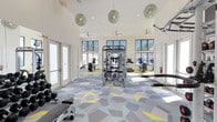 Located at 4320 Commons Dr W in Destin, Florida, this single-floor fitness center offers a welcoming and well-appointed environment for exercise and wellness. The space is anchored by a bold geometric-patterned carpet in shades of gray, teal, and yellow, lending a contemporary aesthetic that energizes the room. High ceilings amplify the sense of openness, while a row of large windows along the walls allows abundant natural light to flood the interior, creating a bright and motivating atmosphere. Ceiling fans are positioned throughout to ensure comfortable airflow during workouts. A standout design feature is the collection of ornate, globe-shaped pendant lights that hang from the ceiling, adding a stylish and unique visual element rarely found in fitness spaces. The facility is equipped with a multi-station cable machine at its center, along with free weights, a weight bench, and a selection of cardio machines including treadmills and ellipticals positioned near the windows. Multiple access doors provide convenient entry and exit points throughout the space. The combination of functional fitness equipment, thoughtful design details, and an airy, light-filled environment makes this fitness center a well-rounded facility for residents and users in the Destin community.