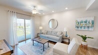 Located at Savona Point in Cape Coral, FL, this well-appointed one-bedroom, one-bathroom unit offers a thoughtfully designed layout across a single floor. The open-concept living room features warm hardwood-style flooring, recessed lighting, a ceiling fan, and a sliding glass door that floods the space with natural light and opens to a private balcony overlooking lush outdoor surroundings. The kitchen is a standout, showcasing tall dark-gray shaker cabinetry, granite countertops, a subway tile backsplash, under-cabinet lighting, and a full suite of stainless steel appliances — ideal for everyday cooking and entertaining. The bedroom is a comfortable retreat with plush carpet, a tray ceiling, a ceiling fan, and a generous walk-in closet outfitted with wire shelving for ample storage. The bathroom is elegantly finished with wood-look flooring, a dark vanity with granite countertops, and a glass-enclosed walk-in shower with tile surround. A dedicated in-unit laundry room with shelving and a hallway connecting all spaces complete this functional and stylish home. The overall ambiance is light, neutral, and modern — perfectly suited for Florida living.