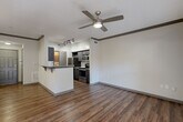 Located at 701 Highland Ave NE in Atlanta's vibrant Grant Park neighborhood, this one-bedroom, one-bathroom unit offers a well-designed, efficient floor plan across a single level. Rich hardwood-style flooring runs throughout the main living areas, complemented by crown molding and a ceiling fan that enhance the open-concept kitchen and living room. The kitchen is outfitted with dark espresso cabinetry, granite-style countertops, a full suite of stainless steel appliances including a refrigerator, range, microwave, and dishwasher, plus a peninsula with bar seating—ideal for casual dining or entertaining. A glass door in the living area allows natural light to fill the space and provides outdoor access. The bedroom features plush carpeting, a large window with natural light, crown molding, and an arched entry leading to a generously sized walk-in closet with wire shelving on three sides. The bathroom includes a tiled tub/shower combination, a granite-topped vanity with white cabinetry, and tile flooring. A dedicated in-unit laundry area with a full-size washer and overhead storage shelf adds everyday convenience. The unit's layout is further enhanced by a hallway connecting each room cohesively.