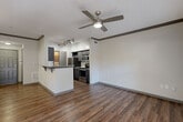 Located at 701 Highland Ave NE in Atlanta's vibrant Grant Park neighborhood, this one-bedroom, one-bathroom unit offers a well-designed, efficient floor plan across a single level. Rich hardwood-style flooring runs throughout the main living areas, complemented by crown molding and a ceiling fan that enhance the open-concept kitchen and living room. The kitchen is outfitted with dark espresso cabinetry, granite-style countertops, a full suite of stainless steel appliances including a refrigerator, range, microwave, and dishwasher, plus a peninsula with bar seating—ideal for casual dining or entertaining. A glass door in the living area allows natural light to fill the space and provides outdoor access. The bedroom features plush carpeting, a large window with natural light, crown molding, and an arched entry leading to a generously sized walk-in closet with wire shelving on three sides. The bathroom includes a tiled tub/shower combination, a granite-topped vanity with white cabinetry, and tile flooring. A dedicated in-unit laundry area with a full-size washer and overhead storage shelf adds everyday convenience. The unit's layout is further enhanced by a hallway connecting each room cohesively.