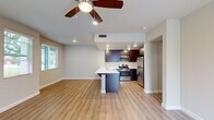 Located at 2740 E Shepherd Ave in Fresno, CA, this two-story home offers 2 bedrooms and 5 bathrooms thoughtfully distributed across two floors. The ground floor is anchored by a bright, open-concept living, dining, and kitchen area finished with warm wood-look laminate flooring and a ceiling fan with recessed lighting. The kitchen is a standout feature, boasting rich dark-wood cabinetry, white quartz countertops, stainless steel appliances including a gas range, microwave, and refrigerator, and a peninsula with bar seating — ideal for casual dining or entertaining. The ground floor also includes an attached garage with built-in lighting and an electrical panel. Upstairs, the two bedrooms are carpeted and bathed in natural light from large windows. The generously sized primary bedroom includes its own closet with built-in shelving. The bathrooms are well-appointed, featuring dark wood vanities with white countertops, a soaking tub, a glass-enclosed shower, and wood-look tile flooring. A dedicated laundry room with a full-size washer and dryer and a private patio round out the home's practical amenities. With four closets and two hallways, storage and circulation are well considered throughout.