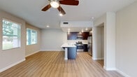Located at 2740 E Shepherd Ave in Fresno, CA, this two-story home offers 2 bedrooms and 5 bathrooms thoughtfully distributed across two floors. The ground floor is anchored by a bright, open-concept living, dining, and kitchen area finished with warm wood-look laminate flooring and a ceiling fan with recessed lighting. The kitchen is a standout feature, boasting rich dark-wood cabinetry, white quartz countertops, stainless steel appliances including a gas range, microwave, and refrigerator, and a peninsula with bar seating — ideal for casual dining or entertaining. The ground floor also includes an attached garage with built-in lighting and an electrical panel. Upstairs, the two bedrooms are carpeted and bathed in natural light from large windows. The generously sized primary bedroom includes its own closet with built-in shelving. The bathrooms are well-appointed, featuring dark wood vanities with white countertops, a soaking tub, a glass-enclosed shower, and wood-look tile flooring. A dedicated laundry room with a full-size washer and dryer and a private patio round out the home's practical amenities. With four closets and two hallways, storage and circulation are well considered throughout.