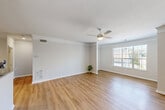 This well-appointed one-bedroom, one-bathroom residence in Birmingham, Alabama offers a thoughtfully designed single-floor layout. The open-concept living, dining, and kitchen area is the heart of the home, featuring light hardwood-style flooring, crisp white walls, and crown molding throughout. A ceiling fan with integrated lighting anchors the spacious living room, which benefits from a large window that invites natural light and outdoor views. Architectural column details add a touch of character to the open floor plan.

The kitchen is equipped with stainless steel appliances — including a refrigerator, range, and microwave — complemented by white cabinetry, granite countertops, a peninsula with an undermount sink, and track lighting overhead. The bedroom is a comfortable retreat with continued hardwood-style flooring, crown molding, a ceiling fan, and closet access. The bathroom features a full tub-shower combination with white tile surround and a granite-topped vanity, maintaining a clean and cohesive aesthetic.

Three closets provide generous storage throughout the unit. The dedicated laundry room houses a full-size washer and dryer alongside wire shelving for additional organization. The space presents a neutral, move-in-ready palette ideal for a variety of furnishing styles.