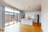 Located in Chicago's sought-after West Loop neighborhood, this well-appointed 2-bedroom, 2-bathroom residence offers a thoughtfully designed single-floor layout. Warm hardwood flooring flows throughout, complemented by crown molding and recessed lighting that add a refined character to every room.

The open-concept living, dining, and kitchen area serves as the heart of the home. The kitchen is outfitted with white shaker cabinetry, a marble-topped island with pendant lighting above, a subway tile backsplash, and stainless steel appliances including a refrigerator and gas range with a statement hood. Full-height sliding glass doors open directly onto a private outdoor terrace, flooding the space with natural light and providing seamless indoor-outdoor living.

Both bedrooms are generously sized, featuring hardwood floors, crown molding, and ceiling fans. The primary bedroom offers ample space and direct access to a well-appointed en-suite bathroom featuring a dual-sink vanity with marble countertops and a tiled tub-shower combination. The second full bathroom mirrors this quality with large-format tile work.

Additional highlights include three closets, a dedicated laundry room, a utility room, and a central hallway connecting all areas efficiently. The layout balances openness and privacy throughout.