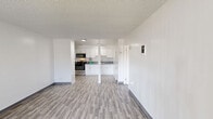 Located at 14300 Mulberry Dr in Whittier, CA, this 1-bedroom, 1-bathroom unit offers a practical and well-organized single-floor layout. Wood-style laminate flooring runs consistently throughout the space, providing a cohesive look, while crisp white walls and textured ceilings create a clean, bright interior.

The open living area is generously sized, featuring a large window that allows natural light to fill the room and provides views of the surrounding neighborhood. A wall unit air conditioner and a front entry door are conveniently positioned within the living space. The layout flows directly into a combined kitchen and dining area, where white cabinetry with modern hardware, a gas range, an over-the-range stainless steel microwave, and quartz-style countertops offer functional cooking amenities.

The spacious primary bedroom features its own window, allowing additional natural light, and connects easily to the rest of the unit. The full bathroom is finished with a clean, all-white tub and shower combo, a toilet, and wood-style tile flooring that complements the rest of the unit. A vanity with stone-style countertop adds a practical finishing touch. Overall, the unit presents a clean, move-in-ready space with consistent modern finishes throughout.