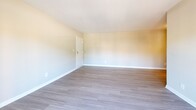 Located at 8501 Walther Blvd in Nottingham, MD, this one-bedroom, one-bathroom unit offers a functional and well-appointed single-floor layout. The living room is a standout feature, highlighted by sliding glass doors that open onto a private balcony overlooking the surrounding community, filling the space with abundant natural light. Durable hard-surface flooring in a light gray tone runs throughout the main living areas, complementing the neutral, warm-toned walls.

The kitchen is positioned adjacent to the living area and features stainless steel appliances, light cabinetry, and a window that brings in additional natural light with views of the outdoors. The generously sized bedroom is carpeted for comfort and includes a large double-door closet for ample storage, along with a secondary door and a window fitted with blinds for privacy and light control.

The bathroom is clean and functional, featuring a full tub-shower combination with white tile surround, brushed nickel fixtures and hardware, a vanity with storage, and light tile flooring. Throughout the unit, white trim and baseboards provide a crisp, polished contrast to the softer wall tones, creating a cohesive and move-in-ready living environment.