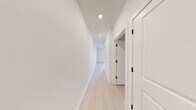 Located at 900 E Sligh Ave in Tampa, Florida, this single-floor unit offers a thoughtfully designed layout that maximizes its compact footprint. The interior features a clean, modern aesthetic throughout, with light wood-look flooring and bright white walls that contribute to an open, airy atmosphere.

The kitchen is a standout feature, outfitted with full stainless steel appliances including a French door refrigerator with ice maker, a gas range, over-the-range microwave, and dishwasher. Crisp white shaker-style cabinetry extends to the ceiling, providing ample storage, while a subway tile backsplash and light-toned countertops complete the contemporary look. Recessed lighting illuminates the space efficiently, and an island provides additional workspace and storage.

The bathroom is finished in a clean, neutral palette, featuring a tub-shower combination with floor-to-ceiling marble-look tile surround and matte black hardware and fixtures, adding a refined contrast to the bright white walls and light flooring.

A dedicated walk-in closet offers wire shelving and hanging space, providing practical, organized storage. The overall design of the unit emphasizes functionality and modern styling throughout.