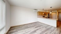 Located in Seattle's Queen Anne neighborhood, this 1-bedroom, 1-bathroom residence offers a thoughtfully designed open-concept layout finished with light-toned luxury vinyl plank flooring throughout. The living area provides a clean, versatile space anchored by a wall-mounted mini-split system for year-round climate control, flowing seamlessly into the kitchen. The kitchen is equipped with warm wood-grain cabinetry, black hardware accents, stainless steel appliances including a full-size refrigerator, electric range, and microwave, as well as a white tile backsplash and a peninsula with pendant lighting — ideal for casual dining or entertaining. A pantry offers additional storage beyond the generous cabinet space. The bedroom is well-proportioned, featuring large windows with views of surrounding greenery, bringing in ample natural light and a calming outdoor connection. A dedicated closet with wire shelving and a vertical storage unit provides organized storage. The full bathroom is finished with a wood-grain vanity, white countertop, large mirror, and a combination shower/tub with black fixture accents. A stacked in-unit washer and dryer adds everyday convenience, completing this efficiently laid-out modern residence.