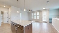 This thoughtfully designed 1-bedroom, 1-bathroom unit offers a comfortable and functional single-floor layout with a cohesive modern aesthetic throughout. The open-concept kitchen and living area forms the heart of the space, anchored by a central kitchen island topped with granite countertops. The kitchen is outfitted with dark espresso cabinetry, stainless steel appliances including a refrigerator, electric range, microwave, and dishwasher, complemented by a double-basin stainless steel sink. Pendant lighting above the island and track lighting add a contemporary touch. The living area extends naturally from the kitchen, featuring light wood-style plank flooring, a ceiling fan, and multiple windows alongside a glass door that fills the space with natural light. The bedroom offers plush carpeting, a ceiling fan, and a window with outdoor views, providing a quiet and comfortable retreat. A dedicated closet provides convenient storage. The full bathroom is finished with a granite-topped dark vanity, a large mirror, and a combination tub and shower. Neutral wall tones and consistent finishes unify the space, creating a clean, move-in-ready environment.