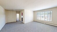 Located at 3400 Terrace Dr in Alexandria, Virginia, this single-floor unit offers three bedrooms, one full bathroom, and a dedicated laundry room. The layout is practical and straightforward, with neutral cream-toned walls and grey carpet throughout the living and sleeping areas, creating a clean, cohesive look.

The spacious primary bedroom is notably generous in size, featuring built-in closets with bi-fold doors and direct access to an additional walk-in closet, providing ample storage. The two secondary bedrooms are each carpeted and equipped with windows fitted with blinds, allowing natural light while maintaining privacy. Baseboard heating units run along the walls in multiple rooms.

The kitchen is outfitted with dark wood upper cabinetry, a white gas range with four burners, and overhead cabinetry for additional storage. The full bathroom features classic pink wall tiles accented with a navy tile border, a full-size soaking tub, chrome fixtures, and a frosted window that brings in diffused natural light.

The living area is open and well-lit, anchored by a large picture window with views of the surrounding neighborhood and mature trees. The unit also includes a dedicated laundry room, adding everyday convenience to this functional Alexandria residence.
