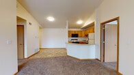 This single-floor residence offers a practical and well-organized layout designed for comfortable everyday living. The open-concept living and kitchen area serves as the heart of the home, where a peninsula-style breakfast bar creates a natural division between the two spaces while maintaining an open, airy feel. The kitchen is fully equipped with oak cabinetry providing generous storage, light-toned countertops, a coil-top electric range, over-the-range microwave, dishwasher, and a full-size refrigerator. Tile-style flooring runs throughout the kitchen and entry areas, while plush carpet covers the living spaces and bedrooms.

The generously sized primary bedroom features a ceiling fan with light fixture and a sliding glass door that fills the room with natural light. A full bathroom is conveniently accessible from this bedroom, complete with an oak vanity, ample counter space, a large mirror, and tile flooring. An adjacent walk-in closet with built-in wire shelving adds practical storage. A second carpeted bedroom offers a bright window with a view of the surrounding neighborhood. Throughout the residence, warm oak wood trim and doors provide a cohesive, classic aesthetic, while neutral wall tones and flush-mount lighting contribute to a clean, move-in-ready environment.