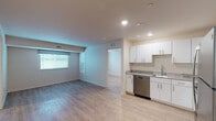 Located at 1012 Shiloh Way in Morrisville, NC, this single-floor residence offers a clean, modern aesthetic throughout. Light wood-tone flooring runs consistently across the living spaces, lending a cohesive and airy feel to the interior.

The open-concept living and dining area is bright and welcoming, with recessed lighting, neutral warm-toned walls, and windows fitted with blinds and curtains that allow for natural light. The layout flows naturally into the kitchen, which is well-appointed with white shaker-style cabinetry, granite countertops, stainless steel appliances including a range, over-the-range microwave, and dishwasher, as well as a stainless steel sink.

Two bedrooms are comfortably sized, each featuring windows with views of surrounding greenery, light wood flooring, and recessed lighting. The rooms provide a calm, functional space with simple, clean finishes.

The residence includes two bathrooms. One full bathroom features a soaking tub and shower combination, a white vanity with granite countertop, and a chrome towel rack. A second bathroom offers a glass-door walk-in shower and matching granite vanity. Both bathrooms maintain consistent light flooring and white cabinetry. A stacked washer and dryer unit is conveniently housed within the full bathroom, adding practical in-unit laundry access.