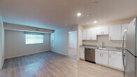 Located at 1012 Shiloh Way in Morrisville, NC, this single-floor residence offers a clean, modern aesthetic throughout. Light wood-tone flooring runs consistently across the living spaces, lending a cohesive and airy feel to the interior.

The open-concept living and dining area is bright and welcoming, with recessed lighting, neutral warm-toned walls, and windows fitted with blinds and curtains that allow for natural light. The layout flows naturally into the kitchen, which is well-appointed with white shaker-style cabinetry, granite countertops, stainless steel appliances including a range, over-the-range microwave, and dishwasher, as well as a stainless steel sink.

Two bedrooms are comfortably sized, each featuring windows with views of surrounding greenery, light wood flooring, and recessed lighting. The rooms provide a calm, functional space with simple, clean finishes.

The residence includes two bathrooms. One full bathroom features a soaking tub and shower combination, a white vanity with granite countertop, and a chrome towel rack. A second bathroom offers a glass-door walk-in shower and matching granite vanity. Both bathrooms maintain consistent light flooring and white cabinetry. A stacked washer and dryer unit is conveniently housed within the full bathroom, adding practical in-unit laundry access.