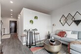 Located at 331 Westport Rd in Kansas City, MO, this contemporary single-floor unit blends modern design with functional living in the heart of the vibrant Westport neighborhood. The open-concept layout connects the living and kitchen areas seamlessly, creating an inviting, cohesive space finished with warm wood-tone flooring throughout.

The kitchen is well-appointed with white shaker cabinetry, white quartz-style countertops, a classic subway tile backsplash, and a full suite of stainless steel appliances, including a range, microwave, and dishwasher. A bold black entry door adds a striking design contrast at the unit's entrance.

The living area is bright and thoughtfully designed, featuring a high accent wall with a warm golden painted ceiling detail that adds visual character. A tall sliding glass door opens to a private balcony, where sweeping views of the Kansas City skyline and surrounding Westport neighborhood pour in, bringing abundant natural light into the space.

The bedroom is a calm, intimate retreat with clean white walls and wood-tone flooring consistent with the rest of the unit. The bathroom offers a frameless glass-enclosed walk-in shower with large-format white tile and chrome fixtures, conveying a clean, spa-like aesthetic throughout.