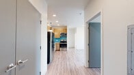 Located at 1440 Independence St in Lakewood, Colorado, this 2-bedroom, 1-bathroom unit offers a thoughtfully designed single-floor layout with a clean, modern aesthetic throughout. Light wood-style flooring runs continuously across all rooms, creating a cohesive and bright atmosphere.

The combined kitchen and living area serves as the heart of the home. The kitchen is well-appointed with warm-toned flat-front cabinetry, stainless steel appliances including a full-size refrigerator, dishwasher, and range, complemented by a teal subway tile backsplash and a modern pendant light above the counter workspace.

Both bedrooms feature neutral walls, large windows that invite abundant natural light, and views of the surrounding neighborhood. The primary bedroom includes a built-in wall-mounted desk and a wall unit for climate control, while the second bedroom also benefits from natural light and a similarly clean, open feel. A dedicated closet provides additional storage.

The full bathroom is finished in crisp white, featuring a soaking tub with shower, chrome fixtures, and wood-style flooring that ties in with the rest of the unit. Gray interior doors provide a subtle modern contrast throughout. The overall design is minimal and functional, making efficient use of the available space.