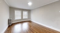 Located on W Fargo Ave in Chicago's West Rogers Park neighborhood, this 2-bedroom, 1-bathroom unit offers a well-organized single-floor layout with a clean, neutral aesthetic throughout. Rich hardwood floors extend across the living areas and bedrooms, complemented by soft gray walls and crisp white trim and baseboards that lend a cohesive, modern feel.

The living room features crown molding and arched doorway details that add architectural character, with natural light filtering in through double windows fitted with white blinds. Both bedrooms are well-proportioned, with the primary bedroom benefiting from multiple windows on two walls, allowing for generous natural light and a bright, airy atmosphere.

The kitchen is outfitted with white shaker-style cabinetry, light quartz countertops, a stainless steel gas range with an under-cabinet range hood, and a window that keeps the space feeling open. The bathroom includes a full soaking tub with a tiled surround in a light neutral palette and a frosted glass window for privacy with natural light.

Connecting hallways provide a practical flow between all rooms, and the overall layout is efficient and functional. The consistent hardwood flooring, updated finishes, and classic architectural details make this a well-appointed Chicago residence.