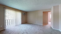 Located at 1743 Market Ave N in Canton, Ohio, this single-floor unit offers a practical and comfortable layout across several well-defined living spaces. The living room is a welcoming, open area finished with plush carpeting and fitted with vertical blinds that cover a large sliding glass door, providing access to a balcony and allowing natural light to fill the room. A wall-mounted air conditioning unit ensures climate control throughout warmer months, while baseboard heating is present throughout the unit for year-round comfort. The kitchen features white cabinetry with ample upper and lower storage, dark laminate countertops, a double-basin sink, and includes a range and refrigerator. The flooring transitions to durable vinyl tile, consistent with the bathroom. The full bathroom is equipped with a tub-shower combination, a toilet, and a vanity, finished with tile flooring. Multiple bedrooms are carpeted and each features a ceiling fan with light fixture, a window with blinds offering natural light and outdoor views, and baseboard heating. One bedroom includes a sliding closet. The neutral, warm-toned walls throughout the unit create a cohesive and understated aesthetic, making each room feel move-in ready.