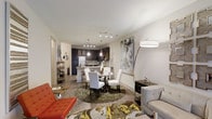 The Birch is a thoughtfully designed 2-bedroom, 2-bathroom residence spanning a single floor. The open-concept layout seamlessly connects the living, dining, and kitchen areas, creating a cohesive and functional living space. The kitchen features dark cabinetry with under-cabinet lighting, a breakfast bar with pendant lighting overhead, and stainless steel appliances, making it ideal for both everyday cooking and entertaining. Track lighting adds a modern touch to the kitchen ceiling. The dining area sits at the heart of the space, accommodating a full dining set and anchored by a textured area rug. The living area offers generous room for comfortable seating arrangements, with warm hardwood-style flooring flowing throughout. Neutral-toned walls provide a versatile backdrop, complemented by contemporary light fixtures including a statement arc floor lamp. The overall ambiance is modern and welcoming, with an efficient use of space that balances style and practicality. The two bedrooms and two full bathrooms offer comfortable private retreats, rounding out this well-appointed residence.