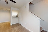 Located at 3505 Redwine Rd in East Point, GA, this two-story home offers a practical and well-appointed layout spread across two evenly sized floors. The main level features an open living room with light hardwood-style flooring, a ceiling fan, track lighting, and a large window that fills the space with natural light. Adjacent to the living area, the kitchen is fitted with white cabinetry, granite countertops, a subway tile backsplash, and stainless steel appliances including a refrigerator and range. A dedicated laundry area on this floor houses a full-size washer and dryer with overhead shelving for added storage. Upstairs, the generously sized bedroom features plush carpeting, a large window with a pleasant outdoor view, and direct access to a walk-in closet. The full bathroom is finished with granite countertops, a white vanity with brushed hardware, and a tiled tub/shower combination. Clean, neutral tones and white trim throughout create a cohesive and move-in-ready aesthetic. A carpeted staircase connects both levels, completing this efficient and comfortable two-story layout.