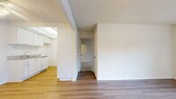Located at 315 N Associated Rd in Brea, California, this efficiently designed one-bedroom unit offers a thoughtful layout across a single floor. The combined living and dining area serves as the heart of the unit, featuring light wood-look laminate flooring, neutral white walls, and large windows dressed with vertical blinds that allow generous natural light to fill the space. A wall-mounted HVAC unit provides climate control directly in the living area.

The kitchen is positioned adjacent to the living space and is equipped with white cabinetry, a white range with coil burners, light granite-style countertops, and overhead lighting, offering a clean and functional cooking environment. A built-in closet in the hallway area provides additional storage convenience.

The bedroom is generously proportioned, featuring plush carpet flooring, a large window with vertical blinds for natural light and privacy, and access to a dedicated walk-in closet with built-in shelving. A second closet offers further storage capacity. The textured ceilings are consistent throughout the unit, contributing to a cohesive aesthetic. The overall design is clean, bright, and functional, making efficient use of the available space in this Brea, CA residence.