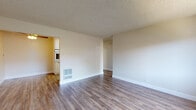 Located at 2777 Marina Blvd in San Leandro, California, this single-floor residence offers a functional and well-organized layout across several distinct living spaces. Throughout the home, a consistent design language is maintained with neutral warm-toned walls, textured ceilings, and clean white baseboards.

The main living area features durable wood-style laminate flooring and an open, airy feel, with direct sightlines into the adjacent galley kitchen. The kitchen is efficiently designed with white cabinetry, a wall oven, a built-in refrigerator, a sink with granite-style countertops, and overhead fluorescent lighting, providing ample storage and functionality.

The bedrooms are carpeted in neutral tones and receive natural light through sliding windows with views of the surrounding neighborhood. Each room is well-proportioned, with wall-mounted heating units ensuring year-round comfort.

Two bathrooms serve the home: one features a full soaking tub with a shower, white tile surround, a window for natural light, and wood-style flooring; the second is fitted with a standalone glass-door shower stall, a single vanity with a mirror, and chrome fixtures. Both bathrooms maintain a clean, minimalist aesthetic. Overall, the space presents a practical and move-in ready environment suitable for comfortable everyday living.