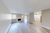 Located in Bothell, WA, this well-appointed 1-bedroom, 1-bathroom residence offers a thoughtfully designed layout across a single floor. The open-concept living and kitchen area forms the heart of the home, anchored by light-toned luxury vinyl plank flooring that runs throughout. The spacious living room is a standout, featuring a classic white-mantled fireplace flanked by windows that invite generous natural light. A sliding glass door provides access to the outdoors, enhancing the sense of openness. A ceiling fan adds comfort to the living space.

The kitchen is efficiently designed with crisp white cabinetry, white quartz countertops, a blue tile backsplash, and stainless steel appliances including a refrigerator, range, and over-the-range microwave. A peninsula counter with a clean white surface connects the kitchen to the living area.

The bedroom offers a comfortable, carpeted retreat with a mirrored sliding closet, a window with a natural rock outcrop view, and a built-in overhead light panel. The adjoining closet area also houses in-unit laundry. The bathroom features a full tub-shower combo, a white vanity with a quartz countertop, and a mirrored medicine cabinet. Neutral warm-gray tones throughout create a cohesive, modern aesthetic.
