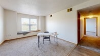 Located at 1407 S 7th Ave in Marshalltown, Iowa, this two-bedroom, two-bathroom unit offers a practical and well-organized single-floor layout. The living room greets you at the entry, featuring wood-look hard flooring near the front door that transitions into plush carpet, with a window that allows natural light to brighten the space. The kitchen is efficiently designed in an L-shaped configuration, outfitted with warm oak cabinetry, ample counter space, and white appliances including a range, dishwasher, and refrigerator, all set over easy-care wood-look flooring. Both bedrooms are carpeted and include natural light from windows with outdoor views. The primary bedroom offers generous proportions and includes a closet with sliding wood-panel doors. The second bedroom also features carpeting and connects conveniently to the hallway. Two full bathrooms serve the unit — one features a vanity with wood cabinetry, a mirror, and a tub/shower combo, while the second includes a clean tub/shower unit with wood-look tile flooring. A hallway connects the main living areas to the bedrooms and bathrooms, completing the functional flow of this well-appointed Marshalltown residence.