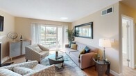 This single-floor residence at 1002 Columbine Dr in Frederick, Maryland, offers a thoughtfully designed layout that balances comfort and functionality. The living room serves as the heart of the home, anchored by a tile-surround fireplace and wall-mounted television, with sliding glass doors that open to a private balcony overlooking lush greenery — filling the space with abundant natural light. Adjacent to the living area, the dining space features warm hardwood-style flooring and a bright window, creating an inviting setting for meals. The kitchen is well-equipped with rich cherry wood cabinetry, dark granite countertops, stainless steel appliances including a refrigerator, range, and microwave, a tile backsplash, and a central island with bar seating — ideal for both everyday cooking and entertaining. The bedrooms are carpeted and tranquil, each offering natural light through window treatments, with the primary bedroom providing ample space and direct access to a private bath. The bathroom is finished with tile flooring, a tub-shower combination, and warm wood vanity cabinetry. Throughout the home, neutral warm-toned walls create a cohesive and calming atmosphere, making this Frederick residence a comfortable and well-rounded living space.